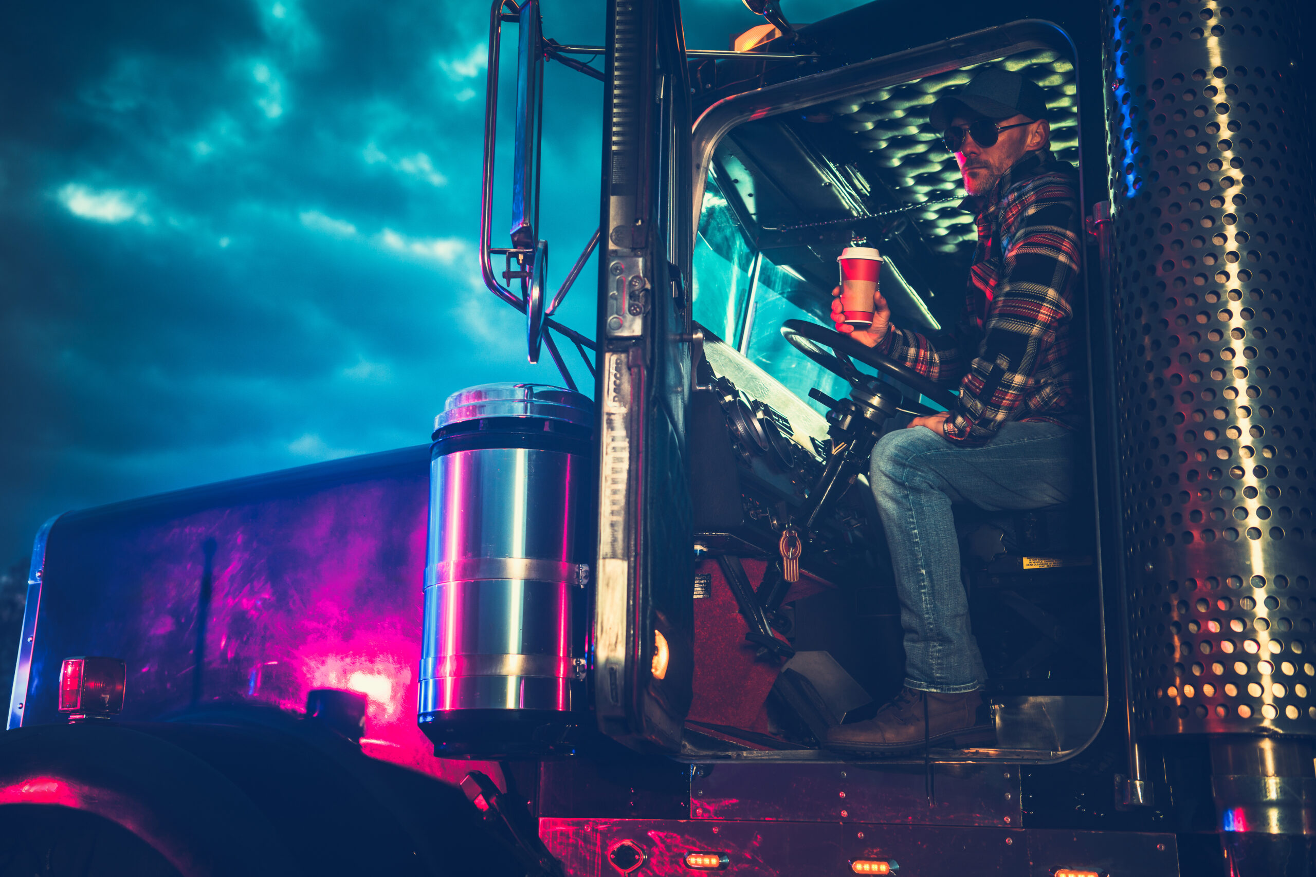 Trucker Driver Drinking a Coffee While on a Truck Stop. Heavy Duty Ground Transportation Theme.