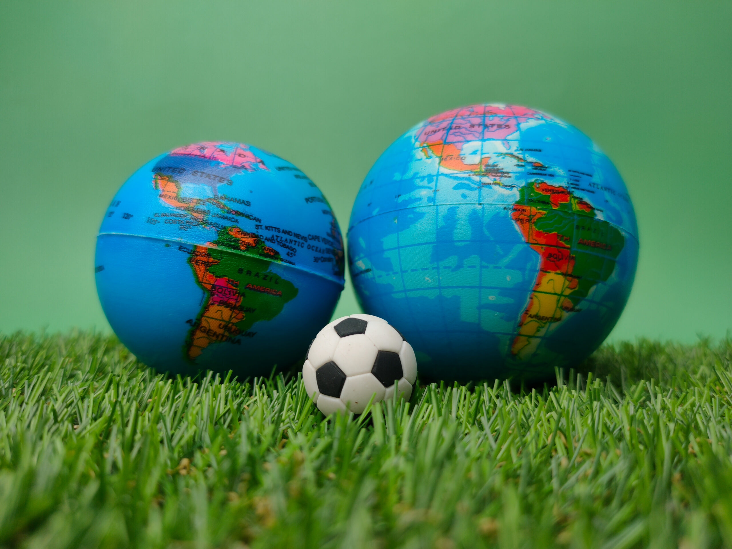 A ball is between globes on a green background