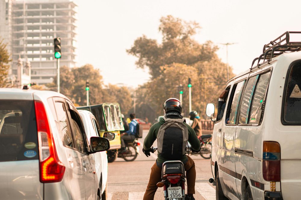 Motorcyclist lane splitting between two cars