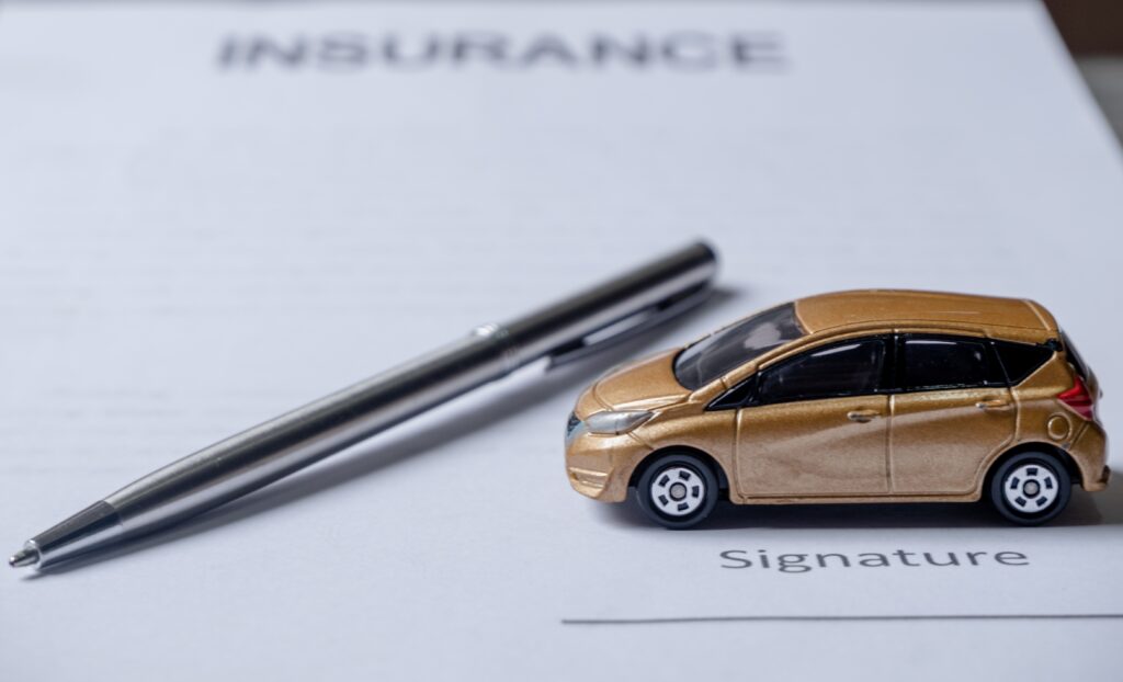 Car and pen on insurance documents.