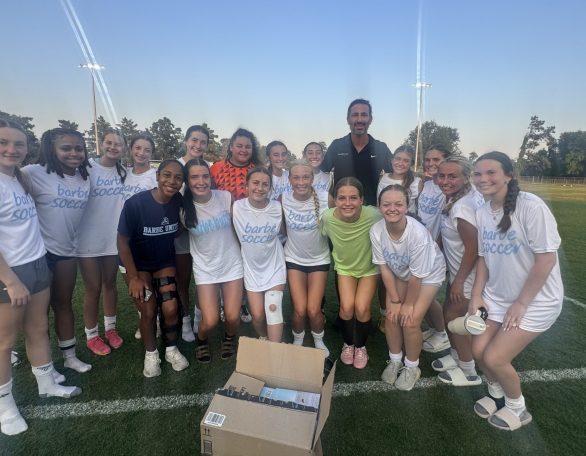 Soccer team poses with Ramez on the field